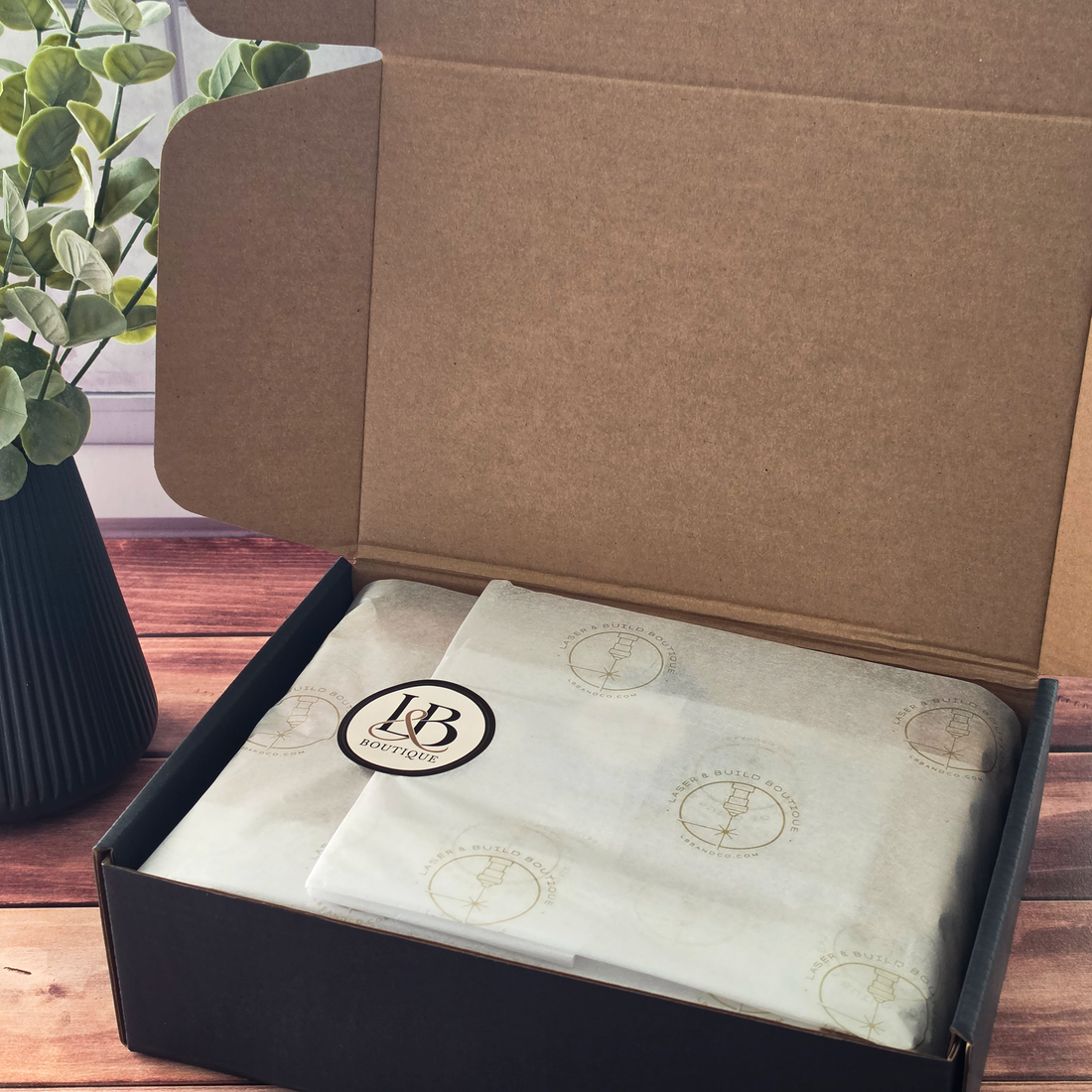 Open Laser & Build Boutique gift box featuring custom branded tissue paper and elegant packaging for personalized gifts.