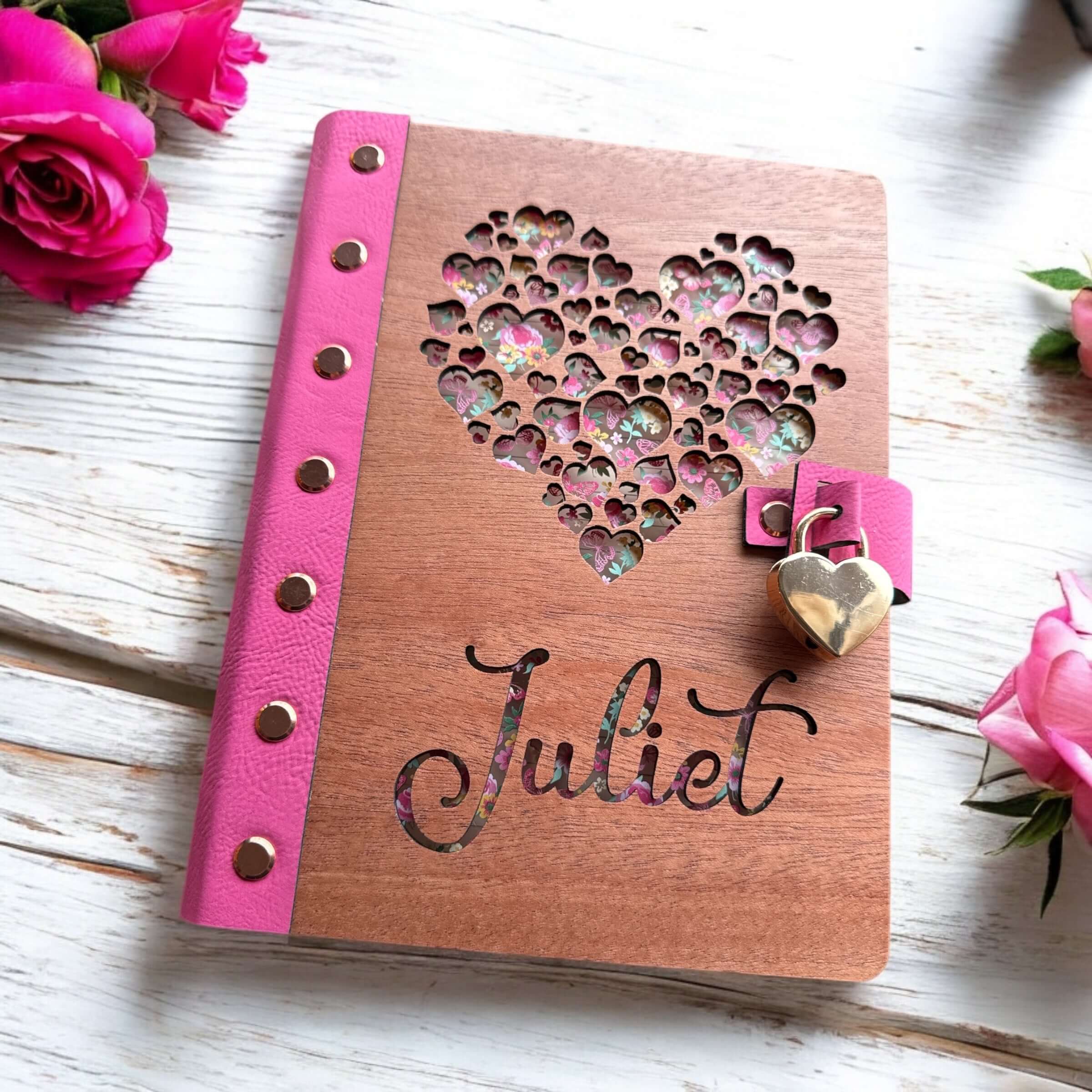 Personalized wood diaries featuring a heart design and name 'Raely' on the cover, part of the Signature Keepsake Collection.