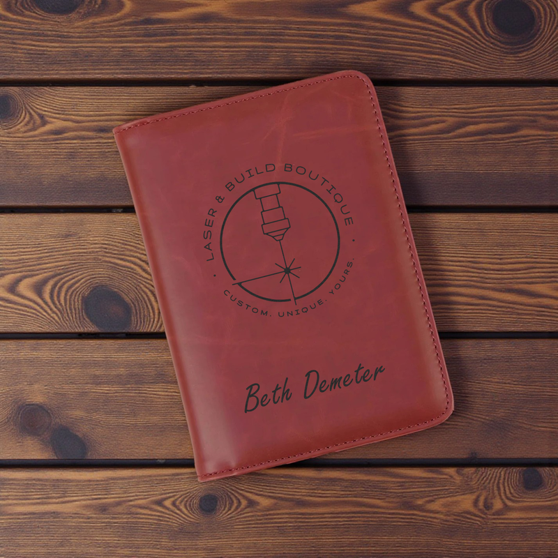 Custom branded tech accessories leather notebook with engraving on wood background