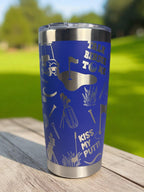 Blue tumbler with golf-themed designs on a wooden surface with a grassy background