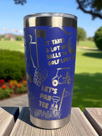 Blue tumbler with golf-themed design on a wooden surface with a golf course background