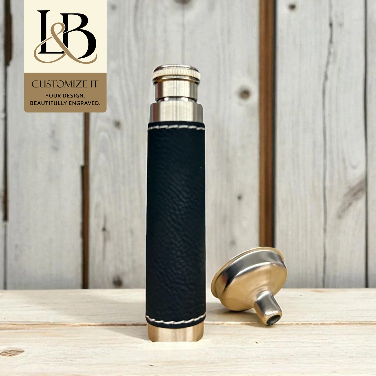Black bottle carrier with metal trim, detached cap and a gold brand badge against pale wood.