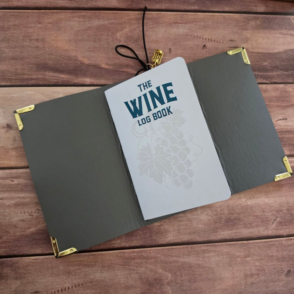 Open Wine journal showing the Wine Log Book title page, dark cover lining and corner protectors.