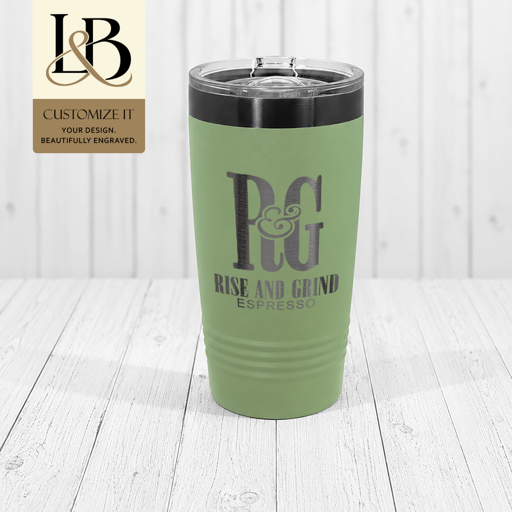 Sage green Rye & Grind Espresso tumbler with dark rim and a gold brand badge against pale wood.