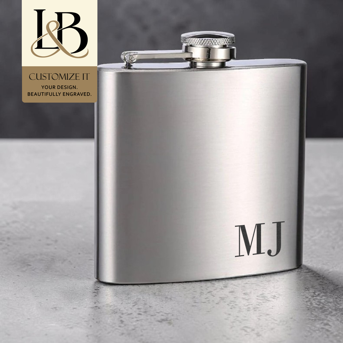 Silver flask engraved with MJ initials and a gold brand badge against a gray backdrop.
